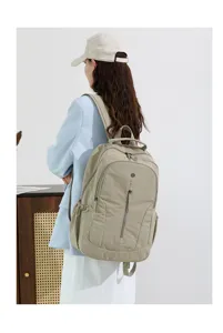 Casual travel backpack detail view showcasing khaki waterproof nylon fabric, front zipper pocket.