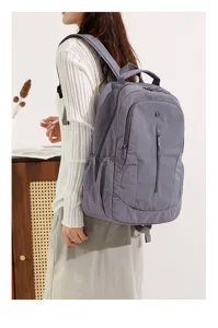 Detail shot of grey casual travel backpack showcasing side pocket and back strap design.