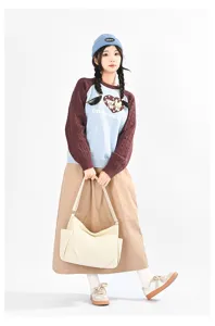 Detail view of casual multi-pocket crossbody bag shown with outfit in studio setting.
