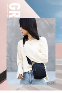 Detail shot of black nylon crossbody bag, casual everyday style with sturdy shoulder strap and zipper.