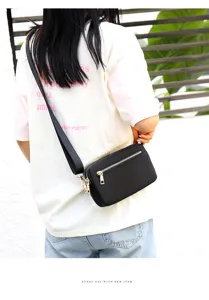 Detailed view of black nylon crossbody bag with zipper pockets and adjustable strap.