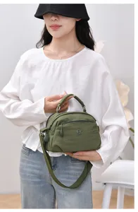 Casual green nylon crossbody bag detail, multiple zipper pockets, adjustable strap design.