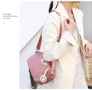 Detailed shot of a stylish pink crossbody shoulder bag worn by model in casual outfit.