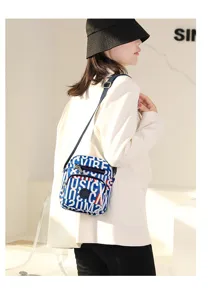 Trendy nylon crossbody bag detail featuring stylish letter print, secure zip and strap.