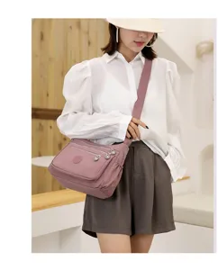Women's multi-pocket nylon crossbody bag, casual shoulder bag with large capacity in pink.