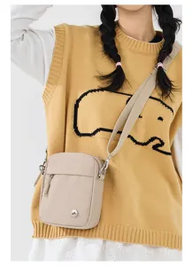 Close-up detail showing the adjustable fabric strap and durable zipper of the mini bag.