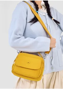 Casual yellow nylon crossbody bag worn by model, showing detail and adjustable strap style.