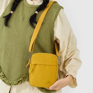 Casual minimalist yellow cross-body phone bag for women, chic small square shoulder bag.