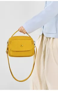 Yellow nylon crossbody bag detail showcasing casual style, compact design and convenient strap.