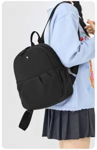 Detail shot of a casual black canvas backpack, lightweight and stylish for daily travel and school.