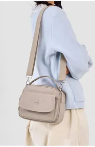 Detail view of casual nylon crossbody shoulder bag, lightweight urban design with wide strap.