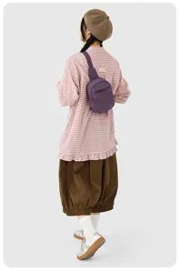 Vue détaillée du sac bandoulière décontracté en nylon violet porté au dos, idéal pour les voyages.