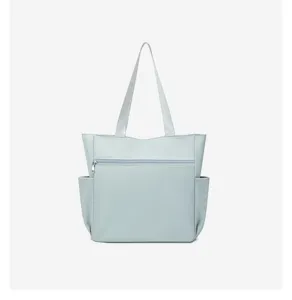 Detail view of the light blue shoulder tote bag showing front zipper pocket and side slip.