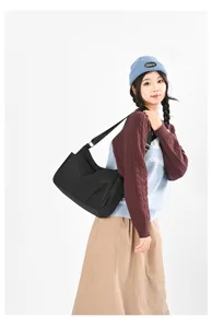 Detailed shot of casual black nylon shoulder bag, large capacity cross-body bag for daily use.