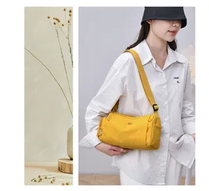 Close-up detail of the yellow multi-pocket cross-body shoulder bag worn by a model in daily life.