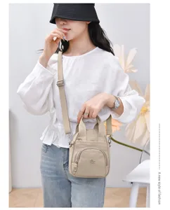 Detalle de bolso bandolera de nailon casual con bolsillo frontal y correa ajustable.