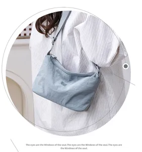 Close-up detail of the casual nylon crossbody bag showing multi-layer storage and blue fabric.