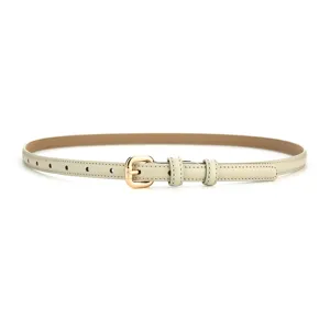 Close-up of slim beige leather belt with gold metal buckle, elegant women accessory detail