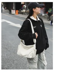 Casual nylon crossbody shoulder bag worn by model in street scene, showing large capacity.