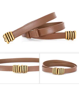 Close-up detail shot of brown leather thin belt with vintage brass metal buckle design.