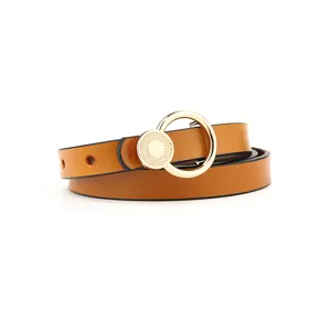 Close-up of a brown leather women belt with gold round buckle minimalist fashion style detail