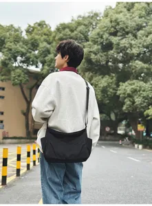 Detail view of the stylish black nylon casual crossbody shoulder bag worn outdoors.