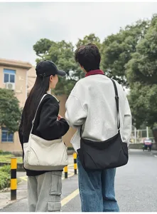 Outdoor lifestyle street view showing the casual nylon crossbody bag worn by models.