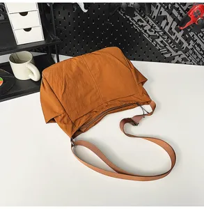 Casual nylon shoulder bag detail view, lightweight slouchy crossbody bag in caramel brown.