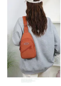 Detailed view of the orange casual sling bag with multi-layer pockets and adjustable strap.