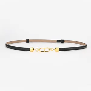 Elegante cinturón de mujer de cuero negro para vestido con elegante hebilla de metal dorada.