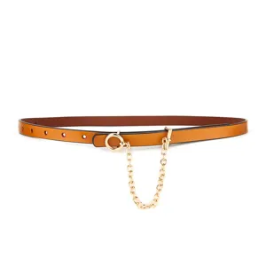 Close-up detail shot of a stylish brown leather belt featuring a gold ring and hanging chain.