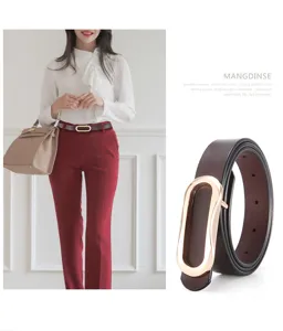 Detailed view of women's slim brown leather belt with elegant gold oval smooth buckle.