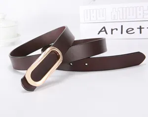 Women's narrow brown leather belt featuring a chic golden oval buckle for casual trousers outfit.