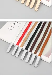 Thin leather belt detail shot showcasing multiple color options and metallic buckles for dresses.