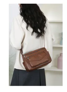 Detailed view of women brown PU leather crossbody shoulder bag with braided accent and multi pocket.