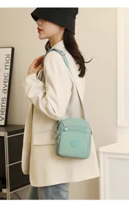 Vue détaillée du sac bandoulière décontracté en nylon pour femme avec multiples poches et sangle.