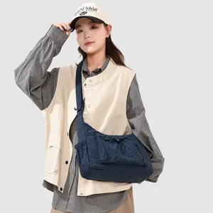Detail view of the blue plaid crossbody bag, featuring a convenient front pocket and durable strap.