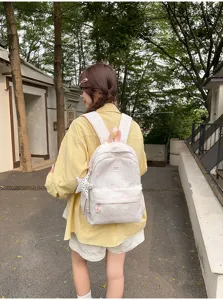 Detailed shot of sweet casual canvas backpack with pink star pattern, outdoor lifestyle.