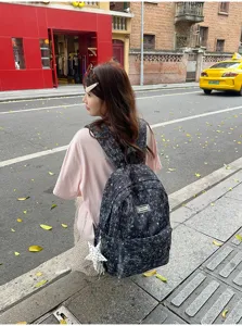 Casual starry sky print backpack for women, stylish student school bag with cute star pendant.
