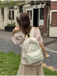 Soft lemon yellow tie-dye backpack for women, aesthetic student book bag with cute pendant.