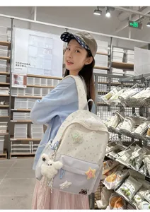 Detailed lifestyle shot of sweet style star embroidered canvas backpack with cute pendants.