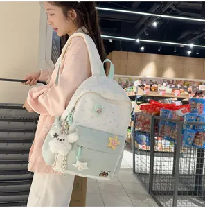 Detailed view of the sweet star embroidered blue backpack with cute plush charm for casual use.