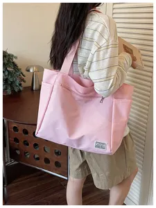 Vue detaillee du sac cabas rose texture avec bandouliere pour les trajets quotidiens.