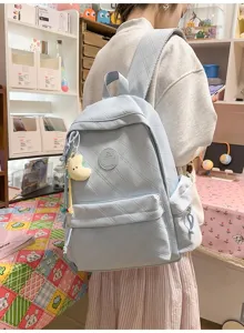 Light blue quilted canvas casual backpack detail view with cute moon plush pendant, daily travel.