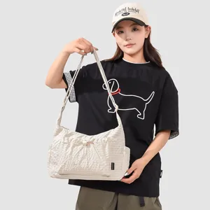 Casual crinkled nylon shoulder bag with front drawstring pocket for daily outdoor use.