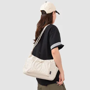 Detailed view of the casual drawstring shoulder bag worn on-model, showing texture and style.