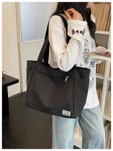 Sac cabas en toile à carreaux noir et blanc avec poignées, poche avant zippée, sac de transport.