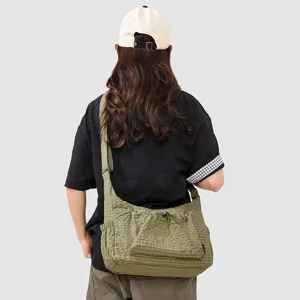 Olive green plaid crossbody bag for women, casual outdoor shoulder bag with drawstring detail.