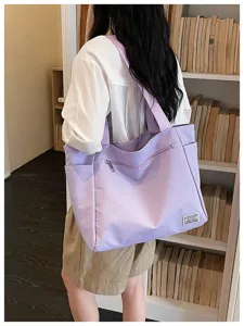 Vue de détail du sac cabas à carreaux violets, montrant le design de sac bandoulière pratique.