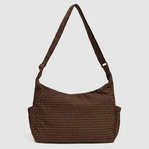 Brown plaid shoulder bag detail, featuring adjustable strap and spacious compartment.